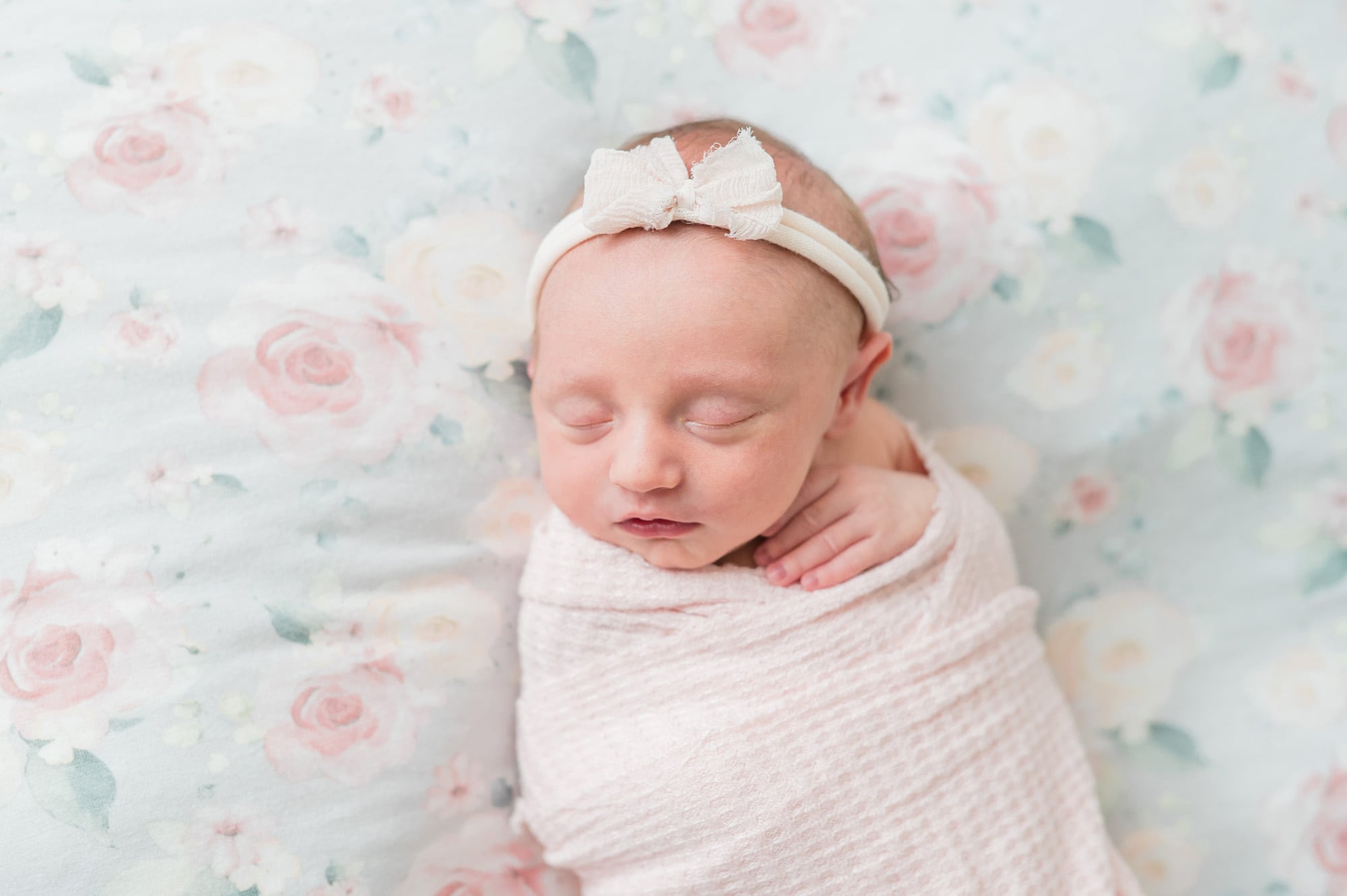 newborn baby with floral blanket